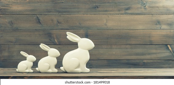 Easter Bunnies Over Rustic Wooden Background. Retro Style Toned Picture