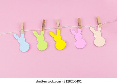 Easter Bunny Craft Paper Garland On Pink Background. DIY Holiday Handicraft Decoration Of Colorful Rabbits. Top View, Cutout. Place For Text