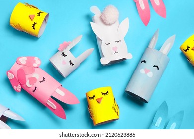 Easter Bunny Craft From Paper Tube Flat Lay. Kids DIY Home Activities. Handmade Cute Toy Rabbits And Chicken On Blue Background Top View. Reuse Concept