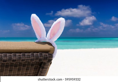 Easter bunny ears on sun chair at a tropical beach setting