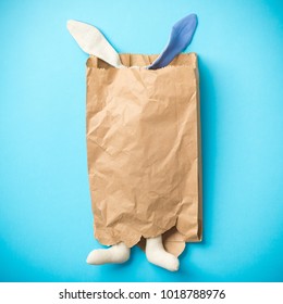 Easter bunny in a paper bag. Rabbit. Blue background. Space for text. 