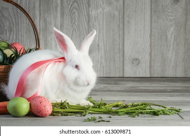 Easter Bunny stands next to carrots and Easter eggs