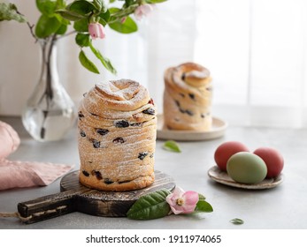 Easter cake Cruffin sweet bread kulich with raisins and painted eggs on window background. Easter holidays breakfast concept.
