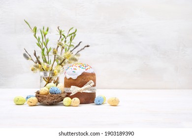 Easter cakes (kulich), eggs and willow branches on white table. Easter holiday scene. Festive composition. copy space