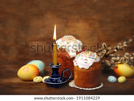 Easter cakes, willow, eggs and candle on rustic wooden table. Easter holiday concept. template for design