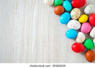 Easter Candy Eggs On White Wooden Surfae