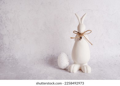 Easter card with white bunny and Easter egg on stone concrete background