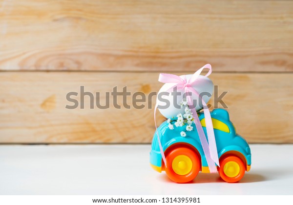 Easter cars with an egg on a white\
background, the concept of the approaching\
easter