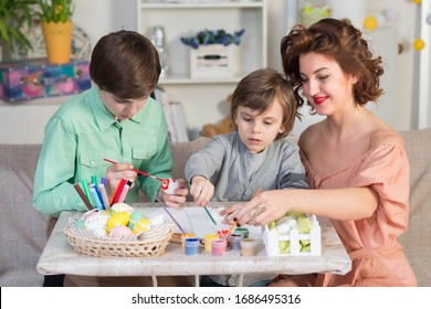 Easter celebration with children doing funny activities like painting eggs and faces - Shutterstock ID 1686495316