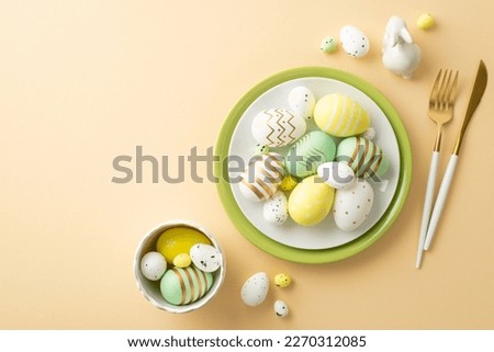 Easter celebration concept. Top view photo of dish with yellow white green easter eggs bowl knife fork and ceramic easter bunny on isolated pastel beige background