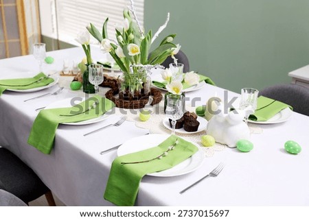 Easter celebration. Festive table setting with elegant dishware and flowers