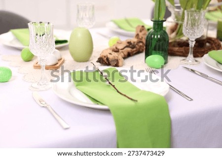 Easter celebration. Festive table setting with elegant dishware and painted eggs, closeup