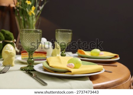 Easter celebration. Festive table setting with elegant dishware and painted eggs, closeup