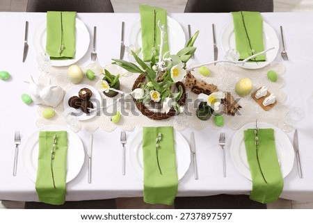 Easter celebration. Festive table setting with elegant dishware and flowers, top view