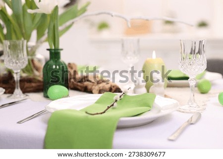 Easter celebration. Festive table setting with elegant dishware and flowers, closeup