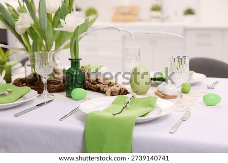 Easter celebration. Festive table setting with elegant dishware and flowers, closeup