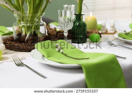 Easter celebration. Festive table setting with elegant dishware and willow branches, closeup