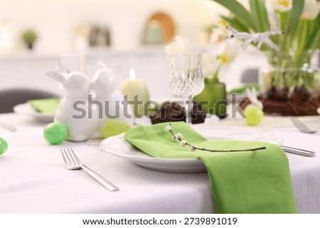 Easter celebration. Festive table setting with elegant dishware and flowers, closeup