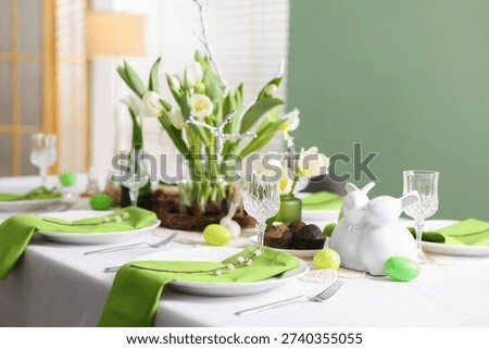 Easter celebration. Festive table setting with elegant dishware and willow branches, closeup