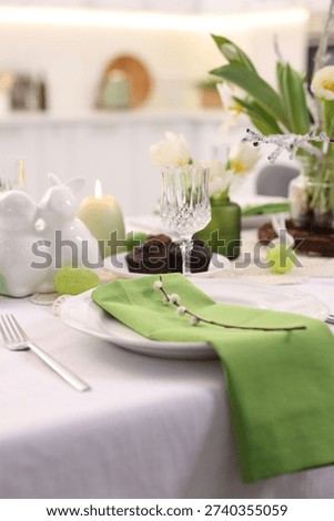 Easter celebration. Festive table setting with elegant dishware and flowers, closeup