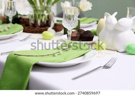 Easter celebration. Festive table setting with elegant dishware and willow branches, closeup