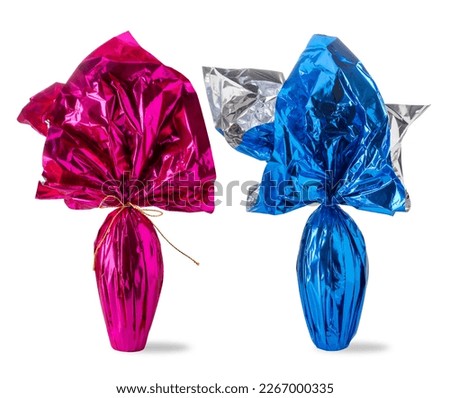 Easter chocolate egg in blue pack with surprise for male and pink pack with surprise for female, isolated on white