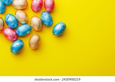 Easter chocolate eggs wrapped in aluminium foil on the yellow background. Top view. - Powered by Shutterstock