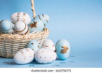 Easter colored eggs in a basket isolated on a trendy blue background. Minimal concept. Card with copy space for text.