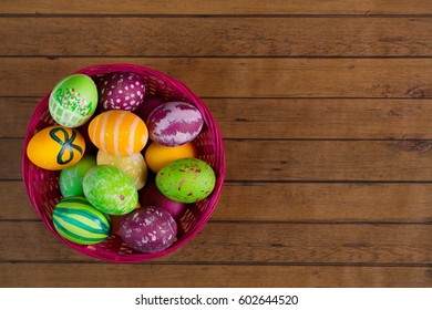 Easter Colorful Eggs In Basket On Wooden Background, Top View