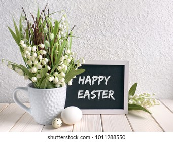 Easter Composition With Blackboard Decorated With Ceramic Hen, Eggs And And Lily Of The Valley Flowers, Caption 