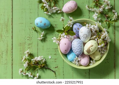 Easter composition. Branches of a blooming apple tree, handmade Easter colorful eggs on a pastel rustic wooden table. Happy Easter Holidays. View from above. - Powered by Shutterstock