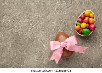 Easter composition with chocolate eggs on grey background, space for text