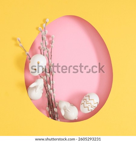 Easter composition with a cut out outline of an Easter egg, cute bunnies, colored eggs and with branches of a blooming willow. Flat lay.