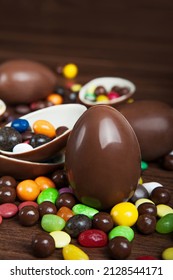 Easter composition with delicious sweets, chocolate eggs on wooden background, space for text. - Shutterstock ID 2128544171
