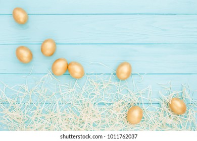 Easter composition of Golden Easter eggs and wood shavings on turquoise wooden background. Easter greeting card, flat lay, top view. - Powered by Shutterstock