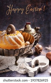 Easter Composition With Homemade Ring Cake Sprinkled With Icing Sugar In Vintage Metal Bowl And Decors On Grunge Background