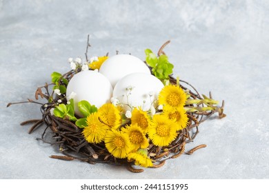  Easter composition in a natural style. Spring flowers arrangements with yellow flowers Tussilago farfara and eggs in the nest. creative floral decoration. side view