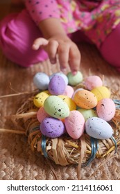 Easter Concept With Child Hand Pick Colorful Egg On Pink Background.