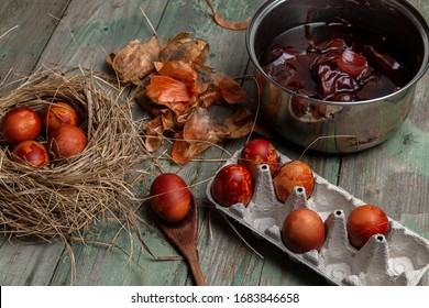 Easter concept. Easter egg coloring.  Easter eggs in an egg palette and nest on an old wooden table. Onion husk in the background - Powered by Shutterstock