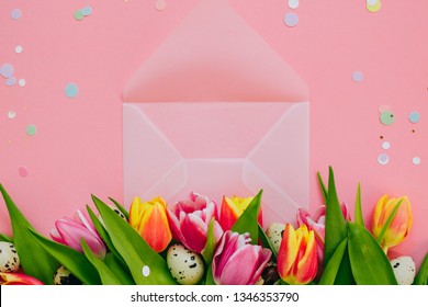 Easter Concept, Golden Star Decorations, Vibrant Confetti And Open Matte Transparent Envelope, Multicolored Tulips And Quail Eggs On Pink Background.