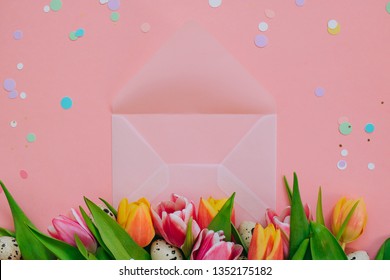 Easter Concept, Golden Star Decorations, Vibrant Confetti And Open Matte Transparent Envelope, Multicolored Tulips And Quail Eggs On Pink Background.