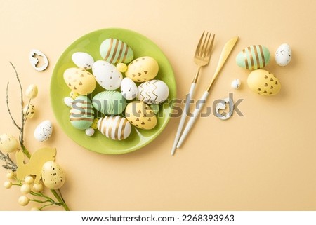 Easter concept. Top view photo of green plate with colorful easter eggs cutlery and easter bouquet on isolated pastel beige background