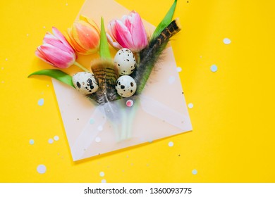 Easter Confetti S And Open Matte Transparent Envelope With Multicolored Tulips An Quail Eggs On Yellow Background.