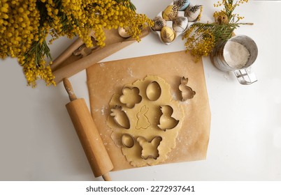 Easter cookie dough and cookie cutters on baking paper close-up
