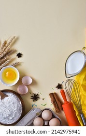 Easter culinary background. Food ingredients for baking - flour, milk, eggs, rolling pin, napkin, whisk, molds on light yellow background. Flat lay composition.Baking or cooking cakes.Vertical photo 