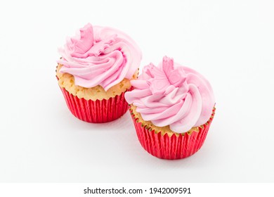 Easter Cup Cakes Two In Number With Pink Icing And Red Sponge Casings On A White Background.