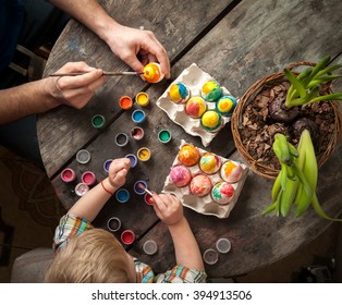 Easter day. Family preparing for Easter. Father and son painting Easter eggs on wooden background. - Powered by Shutterstock