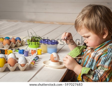 Easter day. Moden Family preparing for Easter. Father and son painting eggs on wooden background. Having fun on Easter egg hunt. Children with colorful eggs in basket. Toddler kid boy play indoor.