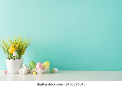 Easter decor idea: A side view of a tabletop displaying a shell-inspired planter with tulips and grass, a ceramic hare, and multicolored eggs in holder, all against a pastel turquoise wall
