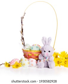 Easter decoration. Easter basket with flowers, eggs and cute Easter bunny isolated on  white  background.